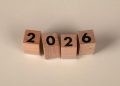 Wooden cubes forming the year 2026 on a neutral background.